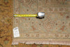 Load image into Gallery viewer, A square area rug with a traditional floral pattern in beige, brown, and muted orange tones, shown with a yellow tape measure across the middle and a white inventory tag reading PIX 23791.