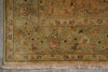 Load image into Gallery viewer, Close-up of an ornate area rug corner showing a muted sage green field with tan, beige, and rust floral motifs, plus a fringed edge.