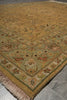 Load image into Gallery viewer, A traditional oriental area rug with a warm mustard yellow field, a sage green inner border, and beige fringe, laid out on a gray tiled floor.