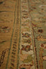 Load image into Gallery viewer, A close-up view of an ornate area rug with a traditional pattern, showing detailed stripes and floral motifs in muted beige, sage green, and brown tones.