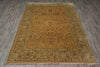 Load image into Gallery viewer, A rectangular area rug with a traditional floral pattern, featuring a warm ochre center and a muted sage green border, laid out on a gray wood-look floor.