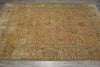 Load image into Gallery viewer, An antique-style oriental area rug with a faded mustard yellow center, a muted green border, and intricate floral motifs in beige, brown, and rust tones, laid out on a gray concrete floor.