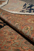 Load image into Gallery viewer, A close-up of a folded area rug showing its detailed traditional pattern in muted tones of rust, beige, blue, and green.