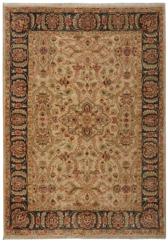 A traditional oriental-style area rug with an intricate floral and medallion pattern, featuring a beige center field, dark navy blue borders, and accents of rust red and green.