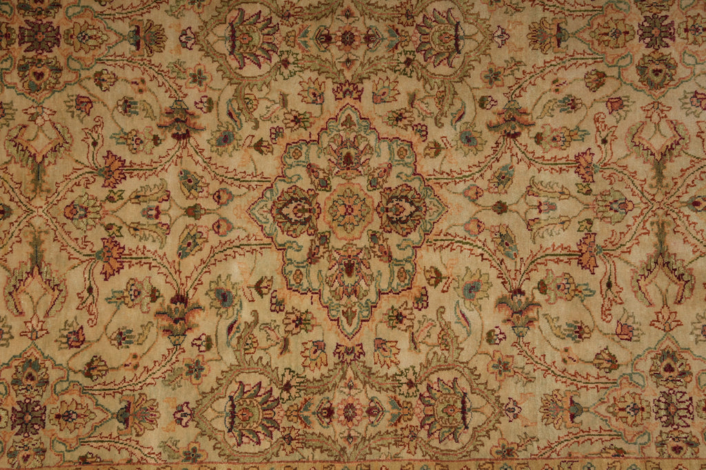An ornate traditional area rug with a central medallion and intricate floral motifs, featuring a warm beige background with red, green, and blue accents.