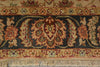 Load image into Gallery viewer, Close-up of an ornate patterned rug with a central floral medallion and fringe along the bottom edge. The design features beige, dark blue, red, and green tones.