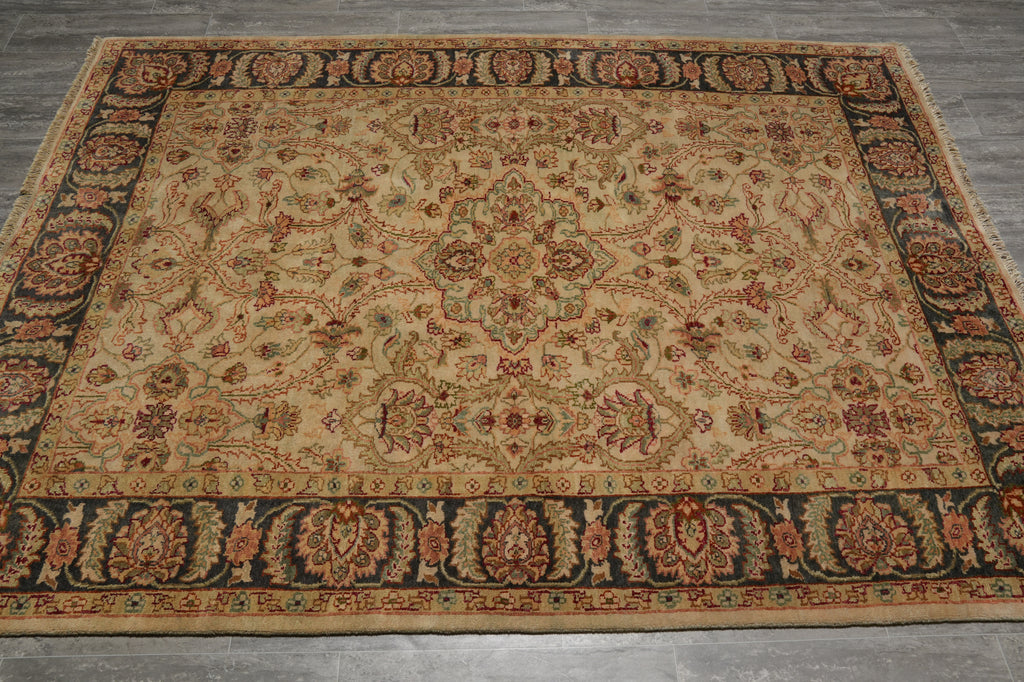 A rectangular vintage-style area rug with an intricate floral and medallion pattern, laid flat on a gray tiled floor.