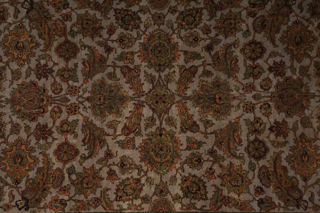 An ornate traditional patterned rug with a dense floral and paisley design in muted brown, rust orange, olive green, and beige tones.