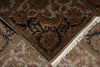 Load image into Gallery viewer, A close-up of an ornate patterned rug corner showing a dark navy central field with floral motifs in rust, gold, olive, and beige, bordered by cream fringe and additional patterned sections.