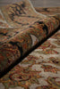 Load image into Gallery viewer, A close-up of a rolled section of a traditional patterned area rug, showing its detailed multicolor design with beige, green, red, and brown tones.