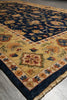 Load image into Gallery viewer, A traditional oriental area rug with a navy blue field, beige border, and multicolor floral motifs, shown laid out on a gray floor.