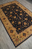 Load image into Gallery viewer, A rectangular area rug with a dark navy blue center field and an ornate golden-yellow border, shown laid out on a gray wood-look floor.