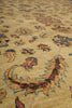 Load image into Gallery viewer, A close-up view of a traditional patterned rug with a warm beige background and multicolored floral and ornamental motifs in muted pink, blue, green, and brown tones.