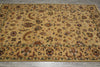 Load image into Gallery viewer, A rectangular area rug with an intricate traditional floral and paisley pattern in shades of beige, brown, and muted green, laid out on a gray tiled floor.