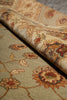 Load image into Gallery viewer, A close-up of a traditional oriental-style area rug with a floral pattern, shown partially rolled to reveal both the patterned top surface and the underside.