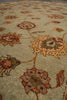 Load image into Gallery viewer, A close-up view of a traditional patterned area rug with a light beige background and large floral motifs in muted orange, brown, olive green, and rust red.
