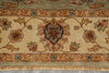 Load image into Gallery viewer, A close-up of an ornate traditional rug with a beige field, floral motifs, and a central medallion, featuring a fringed edge at the bottom.