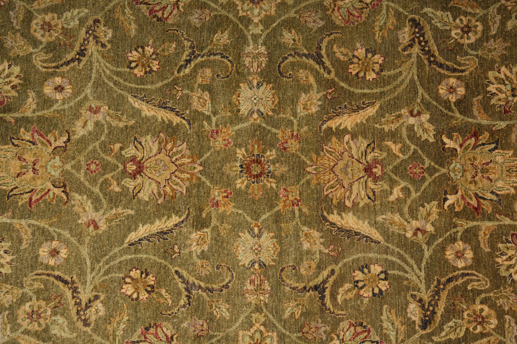 An ornate floral and vine patterned fabric or rug in muted olive green, beige, and rust red tones, shown in a close-up repeating pattern view.