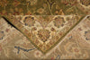 Load image into Gallery viewer, A close-up of a folded area rug showing its intricate floral and vine pattern in beige, olive green, and muted blue tones.