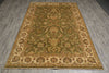 Load image into Gallery viewer, An oriental-style area rug with an intricate floral and vine pattern, shown laid out on a gray wood-look floor. The rug features a dominant olive green center field, a beige border, and accents of brown, gold, and muted red in the detailed motifs.