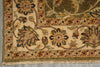 Load image into Gallery viewer, Close-up of an ornate area rug corner showing floral motifs, a decorative border, and fringed edge on a neutral surface.