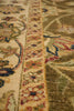 Load image into Gallery viewer, Close-up of a traditional patterned area rug showing a cream central field, a narrow ornate border in beige and rust tones, and a wider olive-green section with floral motifs in blue, red, and cream.