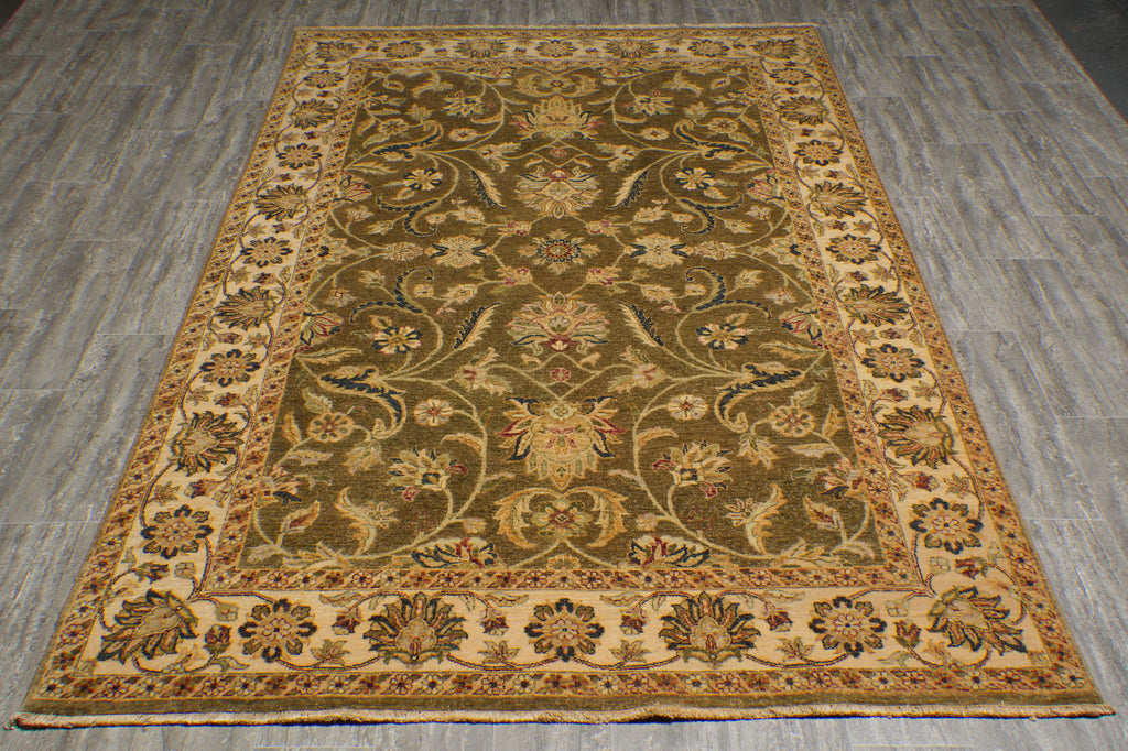 An oriental-style area rug with an intricate floral and vine pattern, displayed flat on a gray wood-look floor. The rug features a dark olive-green center field, a beige and gold border, and accents of red and blue in the floral motifs.
