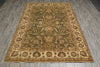 Load image into Gallery viewer, An ornate rectangular area rug with a traditional floral and vine pattern, laid out on a gray wood-look floor. The rug features a dominant olive green center field, a beige border, and accents of brown, blue, and gold in the intricate floral motifs.