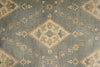 Load image into Gallery viewer, A close-up of a traditional patterned rug featuring a dusty slate blue-gray background with beige and muted gold geometric diamond motifs and floral details.