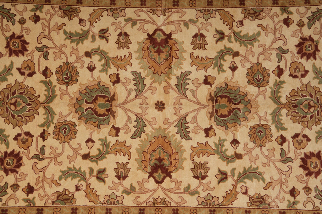 An ornate traditional area rug with a beige background and a detailed floral pattern in muted brown, sage green, and terracotta tones.