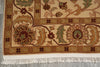 Load image into Gallery viewer, A close-up of a traditional patterned rug showing its cream and beige base, brown floral motifs, green accents, and white fringe at the bottom.