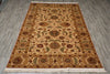 Load image into Gallery viewer, A rectangular traditional area rug with an intricate floral and medallion pattern, laid flat on a gray wood-look floor. The rug features a beige center field, a warm brown border, and cream fringe on the bottom edge.