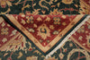 Load image into Gallery viewer, A close-up of an ornate patterned rug folded to show its design and texture. The visible sections feature a deep red central field with cream floral motifs, a dark green border, and cream fringe, layered over a dark green and beige patterned section.