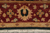 Load image into Gallery viewer, Close-up of a patterned area rug with a deep red field, beige floral motifs, a central dark green medallion, and cream fringe along the bottom edge.