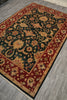 Load image into Gallery viewer, A traditional oriental-style area rug with a dark green central field, red borders, and beige floral motifs, shown laid out on a gray wood-look floor.