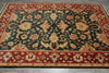 Load image into Gallery viewer, A rectangular area rug with an ornate floral and vine pattern, featuring a dark green center field, red borders, and beige accents, laid out on a gray floor.