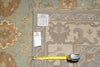 Load image into Gallery viewer, A patterned area rug shown with a tape measure and inventory tags on a matching rug surface, likely documenting size and condition.