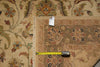 Load image into Gallery viewer, A close-up of a patterned area rug with a beige base and multicolor floral motifs, shown with a yellow tape measure and a product tag to indicate size.