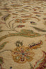 Load image into Gallery viewer, Close-up of a traditional patterned rug with a beige background and floral motifs in muted green, brown, and rust red.