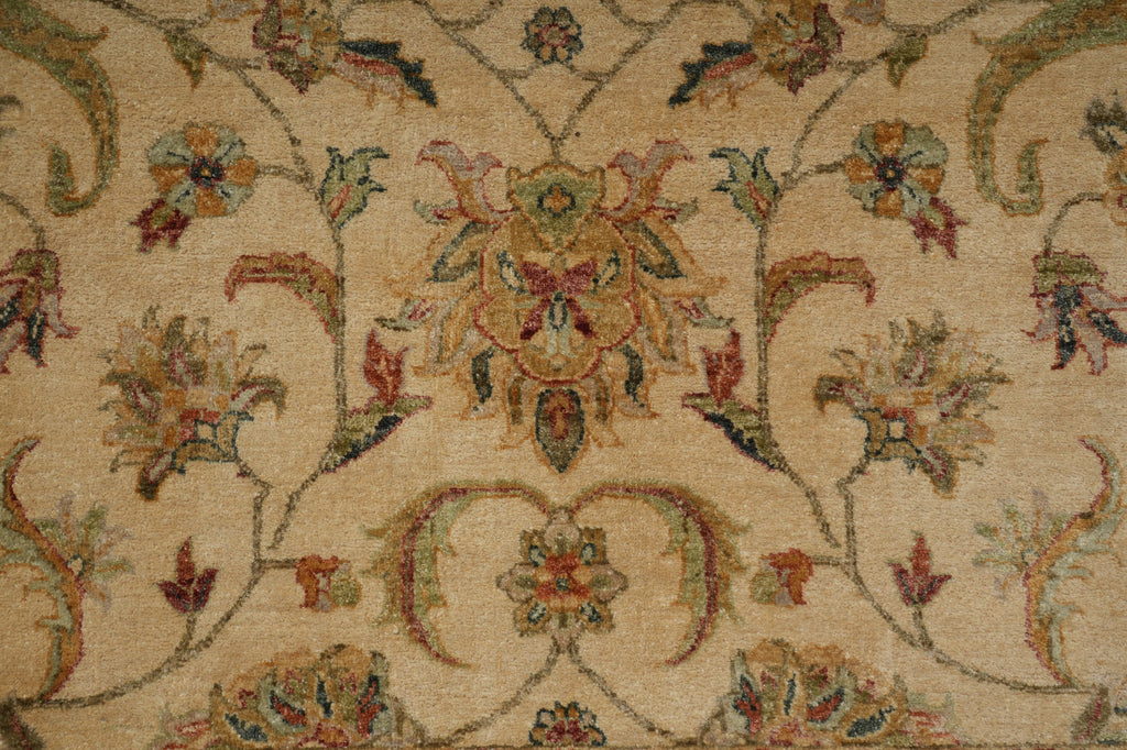 Close-up of a traditional floral patterned rug with a beige background and multicolored motifs in muted green, rust red, and blue.