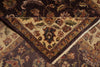 Load image into Gallery viewer, A close-up of an ornate traditional area rug with a folded corner revealing its cream center and dark brown floral borders, layered over another similar rug.