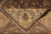 Load image into Gallery viewer, A close-up of an ornate area rug showing its detailed woven pattern, featuring a central cream-colored triangular medallion with floral motifs and fringed edges, surrounded by a brown and beige paisley design.