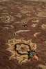 Load image into Gallery viewer, Close-up of a traditional patterned rug in warm brown tones with cream, red, and muted blue floral motifs.