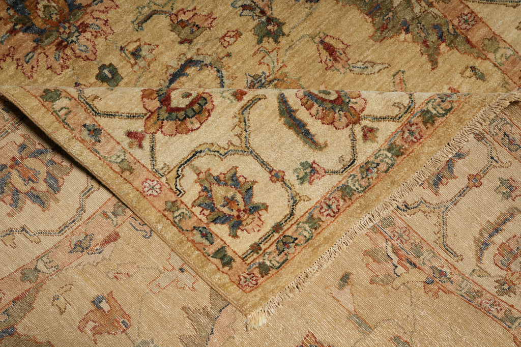 A close-up of a traditional oriental rug with a beige base and intricate floral motifs in muted red, blue, green, and brown tones.