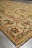 Load image into Gallery viewer, A close-up diagonal view of a traditional patterned area rug with a cream and beige base, featuring floral motifs in muted red, green, and blue, with a fringed edge.
