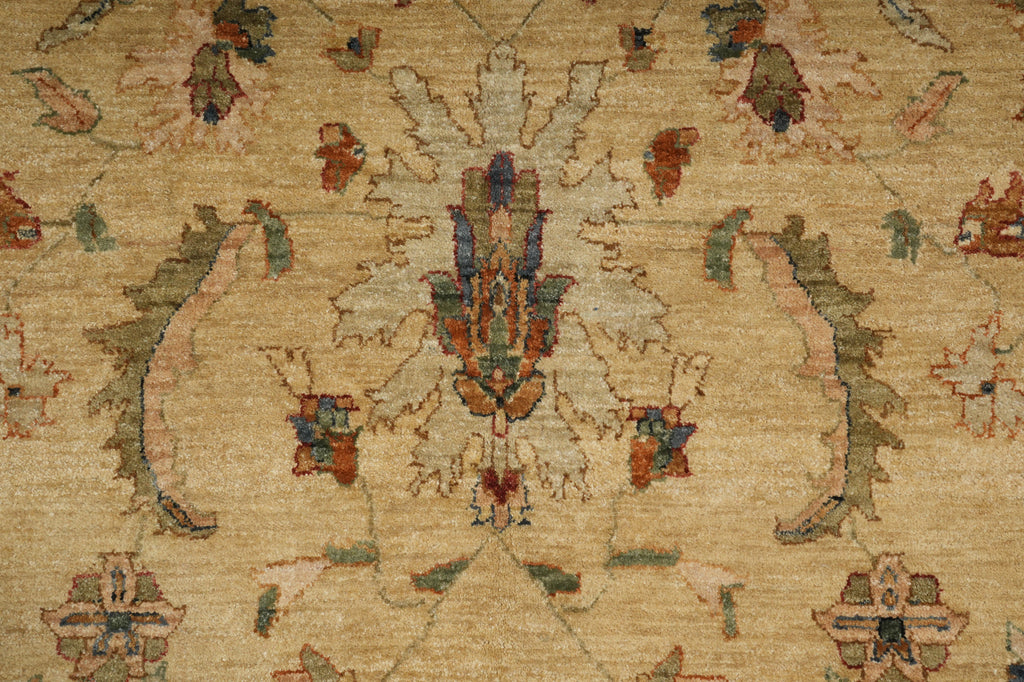 A close-up of a traditional patterned rug with a beige background and ornate floral motifs in muted red, green, blue, and brown.