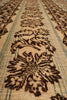 Load image into Gallery viewer, Close-up of a woven rug or textile with a repeating floral pattern in dark brown on a warm beige background, with thin muted green stripes running horizontally.