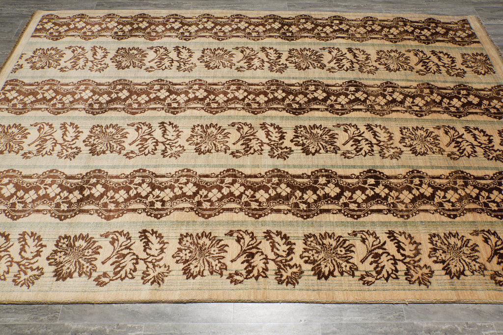 A rectangular area rug with a traditional floral and geometric pattern in dark brown on a natural beige jute background, laid flat on a gray tiled floor.