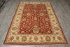 Load image into Gallery viewer, A rectangular traditional area rug with an ornate floral and botanical pattern, featuring a deep red central field, cream-colored borders, and accents of green, gold, and brown, displayed on a gray wood-look floor.