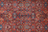 Load image into Gallery viewer, A close-up of a traditional patterned rug with a warm red-orange field, blue and beige medallions, and intricate floral motifs.